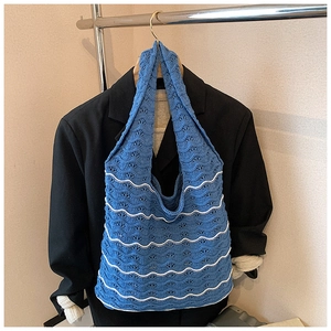 Detail of blue and white striped knit tote bag showing intricate woven texture and strap