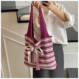 Dettaglio borsa tote in maglia a righe viola e crema con un grande fiocco decorativo