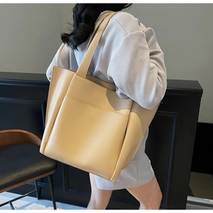 Detail of beige tote bag with litchi texture and functional front open pocket