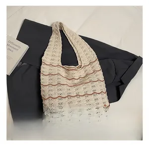 Detail showing the bohemian hollow-out knit texture and wavy brown stripes of the tote bag