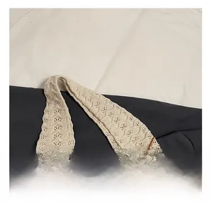 Detail of woven knit handbag with cream base and brown wave patterns and hollow texture