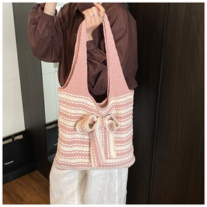 Dettaglio della borsa tote in maglia a righe rosa e bianche con grande fiocco