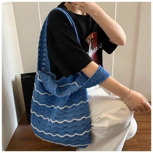 Detail of blue and white wavy knit tote bag featuring hollow crochet texture and large capacity
