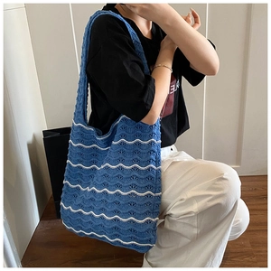 Detail of blue and white crochet knit tote bag showing woven texture and wave patterns