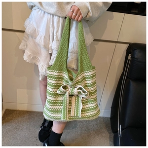 Dettaglio della borsa tote in maglia a righe bianche e verdi con fiocco decorativo