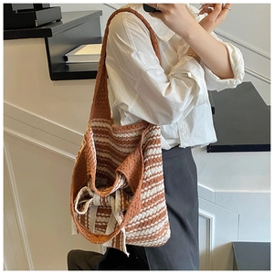 Dettaglio della borsa tote retrò intrecciata a strisce bianche e marroni con fiocco laterale
