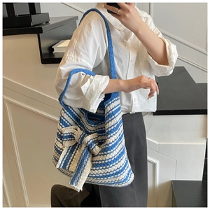 Dettaglio della borsa tote in maglia a righe blu e bianche con grande fiocco 3D