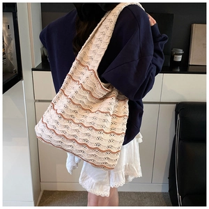 Side view of large hand-woven tote bag with orange wave patterns on beige texture