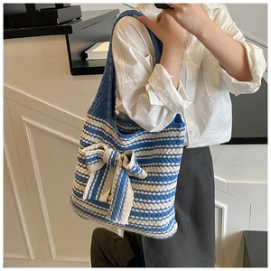 Dettaglio della borsa tote in maglia a righe blu e beige con grande fiocco decorativo