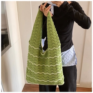Detail view of green and white crochet knit tote bag with wavy hollow pattern
