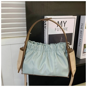 Detail der hellblauen Falten-Tasche mit beigem Ledergriff und schickem Design