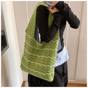 Detail view of woven knit tote bag with vibrant green and white wavy textured pattern