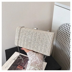 Dettaglio pochette in paglia intrecciata crema con chiusura argento e catenina fine