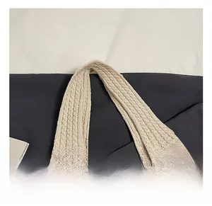 Detail shot of the thick knit handle on a cream tote bag with pink bow pattern texture
