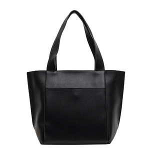 Minimalist black lychee leather tote bag with wide handles for daily commute on white background