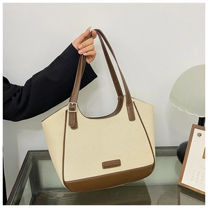 Detalle del bolso tote de lona con adornos de cuero marrón y parche de logotipo