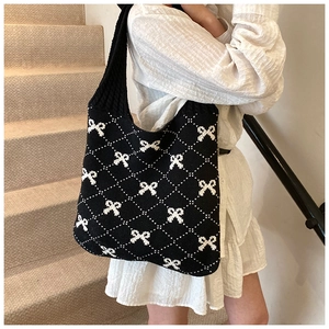 Detailed view of the woven bow pattern and knit texture on the large shoulder bag