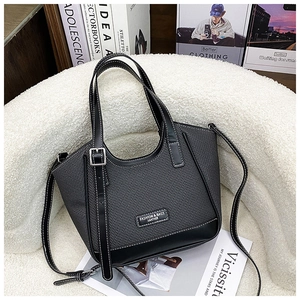 Détail du sac cabas tissé gris avec bordure en cuir noir et surpiqûres blanches
