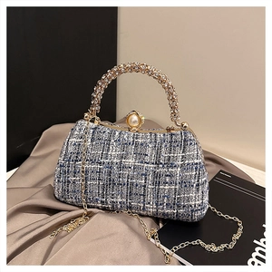 Close-up of tweed evening bag featuring pearl clasp, rhinestone handle and chain strap