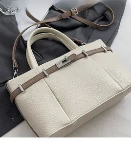 Detail of cream lychee leather tote with brown straps and silver metal buckle closure