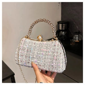 Close-up of tweed evening bag featuring a rhinestone metal handle and pearl clasp