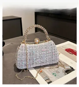 Detail of tweed evening bag with rhinestone handle and pearl clasp on marble