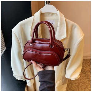 Chic burgundy bowling handbag in glossy faux leather with silver hardware and shoulder strap