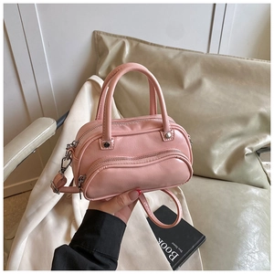Detail of pink PU leather Boston bag with lychee texture and crescent front pocket