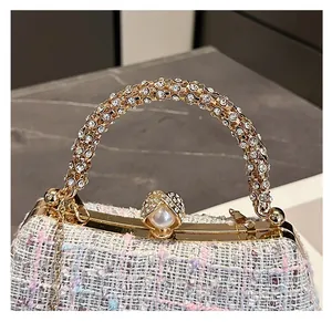 Detailed view of luxury tweed evening bag with rhinestone handle and pearl clasp