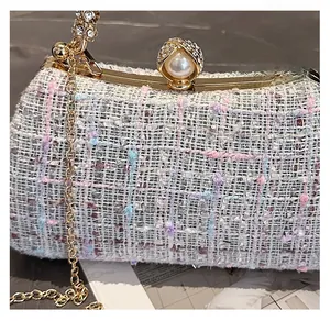 Detail of tweed evening bag with a large pearl diamond clasp and gold chain strap