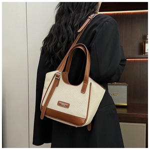 Gros plan d'un sac cabas vintage en paille crème avec des lanières en cuir marron