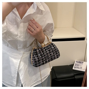 Detail of tweed crossbody bag with pearl clasp and rhinestone-encrusted handle