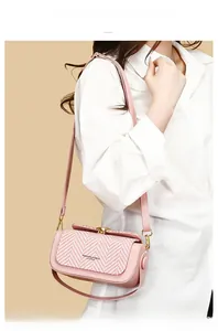 Close-up of pink quilted shoulder bag featuring herringbone weave and metal clasp