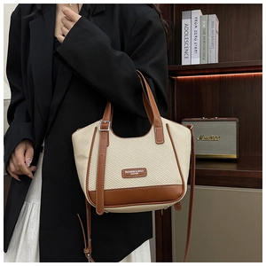 Détail du grand sac cabas tissé avec bordure en cuir marron et plaque de mode