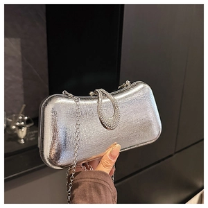 Close-up of silver textured evening clutch bag with rhinestone U-shaped buckle and chain