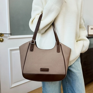 Detalle del bolso tote de lona con correa de cuero ajustable y parche de logo