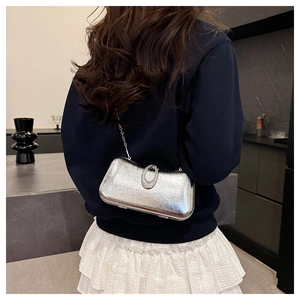Close-up of silver sequin evening clutch bag with sparkling rhinestone ring clasp and chain