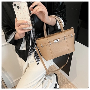 Close-up of light brown pebble grain leather tote bag with silver buckle and shoulder strap