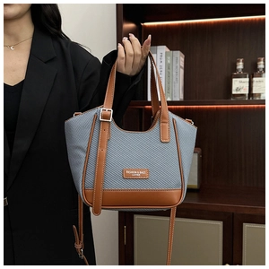 Détail du sac cabas en tissu à carreaux bleus et finitions en cuir marron chic
