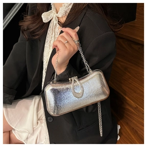 Macro shot of silver evening bag texture with crystal clasp and chain strap detail