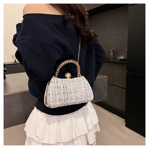 Detail of tweed evening bag featuring rhinestone metal handle and pearl clasp closure