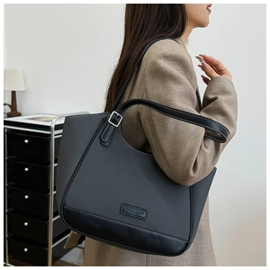 Vista lateral de un bolso tote de tejido gris oscuro con acabados en cuero elegante