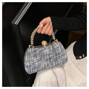 Detail of blue tweed evening bag with pearl handle and rhinestone clasp closure