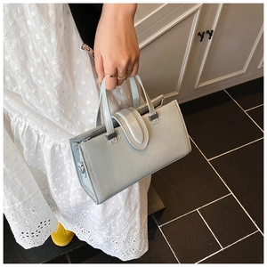 Détail du sac carré bleu clair minimaliste avec ferrures argentées et cuir lisse poli