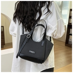 Détail du sac cabas noir avec coutures contrastées en sergé et bandoulière en cuir
