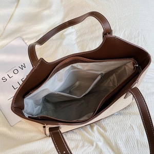 Detalle del interior del bolso tote de lona con ribete de cuero y forro de espiga