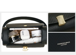 Detail view of black cylinder bag interior showing high capacity and gold hardware