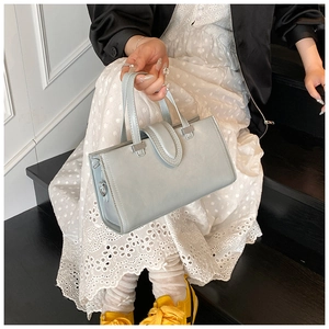 Détails d'un sac à main bleu clair avec coutures et éléments d'anneaux en métal