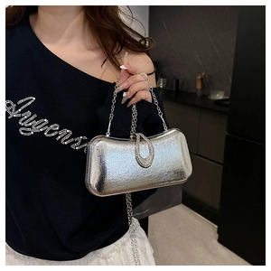 Close-up of silver textured evening clutch with rhinestone buckle and chain strap