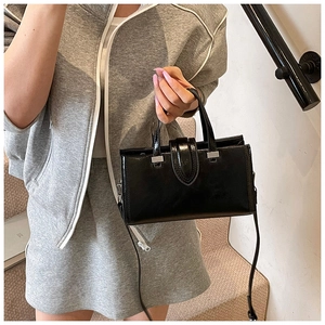 Sac à bandoulière chic en cuir verni noir avec boucle argentée et sangle réglable